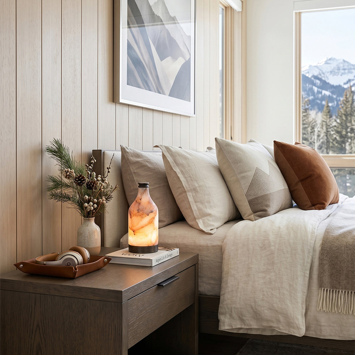 Aldric Alabaster Flask Table Lamp | Natural Alabaster Stone and Bronze Metal | Sitting on a wooden nightstand beside a comfortable bed in a bright mountain view bedroom | Severn Lighting