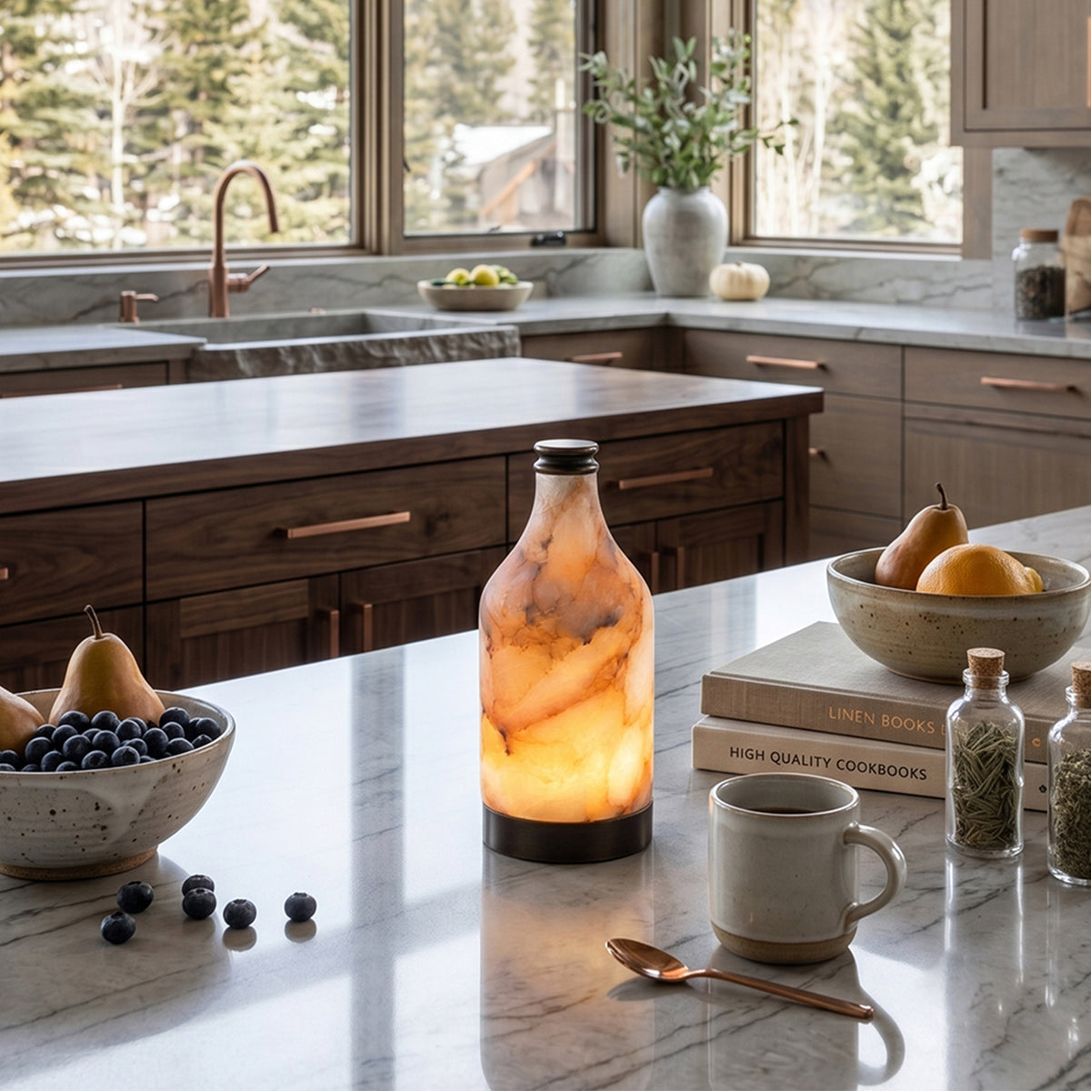 Aldric Alabaster Flask Table Lamp | Natural Alabaster Stone and Bronze Metal | Placed on a white marble kitchen island counter next to fruit bowls and a coffee mug | Severn Lighting