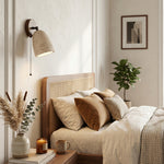 Aria Travertine Wood Wall Lamp | Travertine, Wood, Metal | Mounted as an elegant bedside lamp over a classic wooden bed with neutral pillows in a cozy bedroom | Samu Lamp
