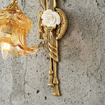 Armelle Rose Glass Brass Wall Lamp | Glass, Ceramic and Brass | Mounted on a concrete grey wall showing the white rose element | Severn Lighting