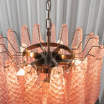 Aubine Pink Textured Glass Tiered Chandelier | Pink Textured Glass and Brass | Angled top view of glowing pink textured glass petals and inner lights | Severn Lighting