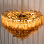 Auriane Fluted Amber Glass Chandelier | Fluted Amber Glass and Brass | Top perspective view glowing against a textured wall backdrop | Severn Lighting