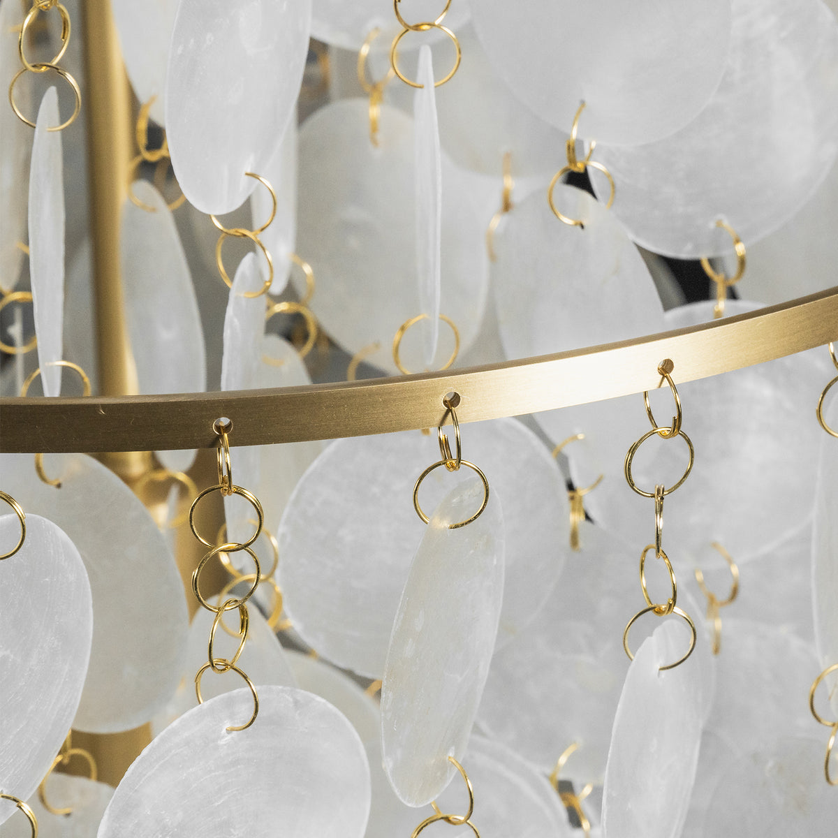 Callista Tiered Capiz Table Lamp | Capiz, Metal | Close-up focus on the gold brass multi-tier frame structure highlighting the small metal wire loops holding the capiz discs | Detail shot | Severn Lighting