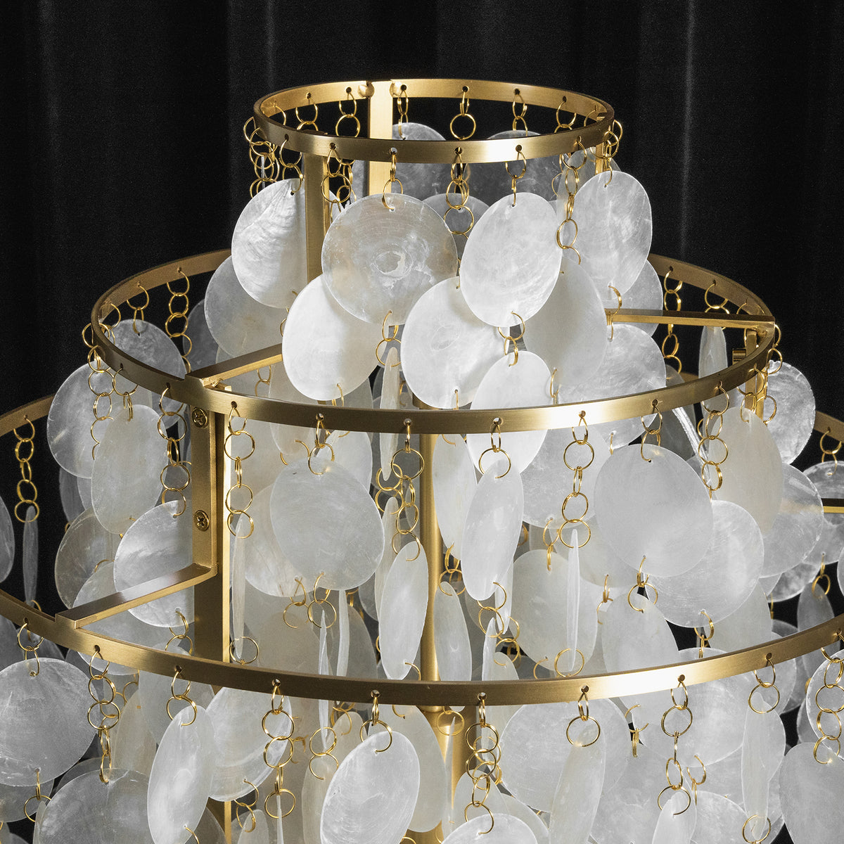 Callista Tiered Capiz Table Lamp | Capiz, Metal | Top-down structural perspective of the concentric circular gold frames densely packed with hanging strands of capiz shells on a black background | Detail shot | Severn Lighting