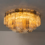 Cassian Tiered Fluted Glass Ceiling Light | Tiered Fluted Glass and Gold Brass | Symmetrical view of the multi-layered flush mount fixture glowing brightly on a plain ceiling | Severn Lighting