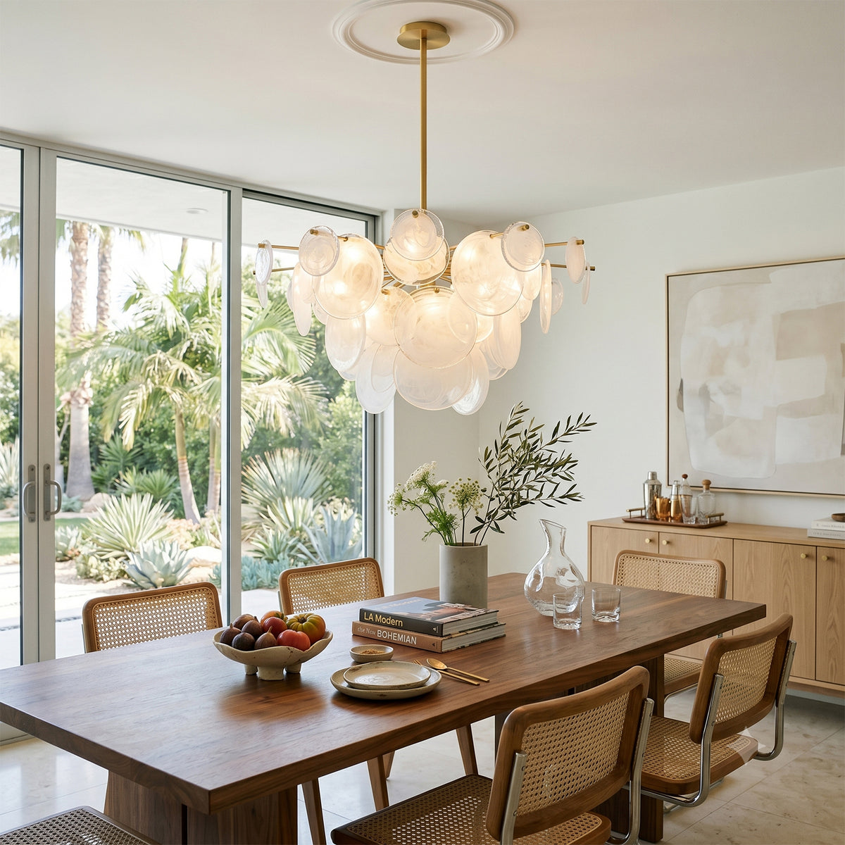 Celestia Art Glass Disc Chandelier | Glass, Metal | Positioned as an artistic centerpiece over a light wood dining table with flowers in a modern sunlit coastal lounge space | Severn Lighting