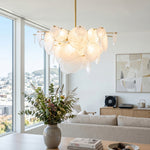 Celestia Art Glass Disc Chandelier | Glass, Metal | Wide-angle view of the elegant cluster chandelier illuminating a refined dining room with a long wood table and rattan chairs | Severn Lighting