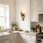Clemency Winged Figure Brass Sconce | Cast Brass and Glass | Installed on a white paneled wall in a classic kitchen area | Severn Lighting