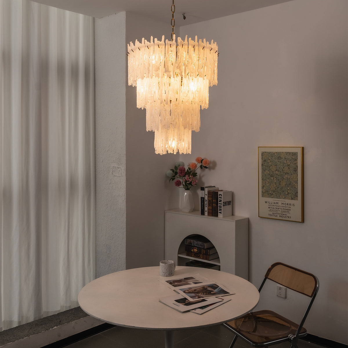 Ethereal Icicle Waterfall Chandelier | Frosted Icicle Glass and Gold Brass | Placed above a minimalist white round dining table in a cozy dimly lit room corner | Severn Lighting