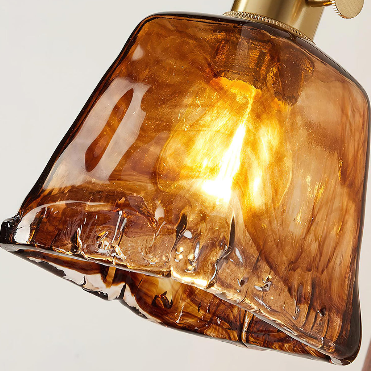 Everett Amber Ripple Wall Sconce | Amber Rippled Glass and Walnut Wood | Extreme close-up shot of the warm amber rippled glass shade and filament bulb | Severn Lighting