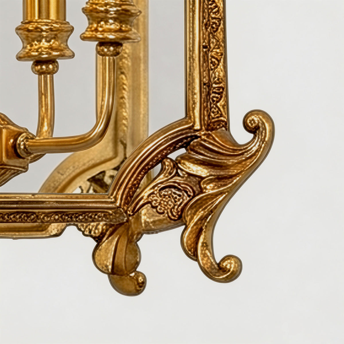 Florian Fretwork Brass Lantern Pendant Light | Glass and Brass | Macro close-up of the carved brass corner scroll foot on a white background | Severn Lighting