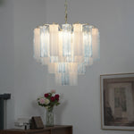 Givrane Two-Tone Glass Tube Tiered Chandelier | Two-Tone Glass and Brass | Real-life view hanging gracefully against a plain grey wall | Severn Lighting