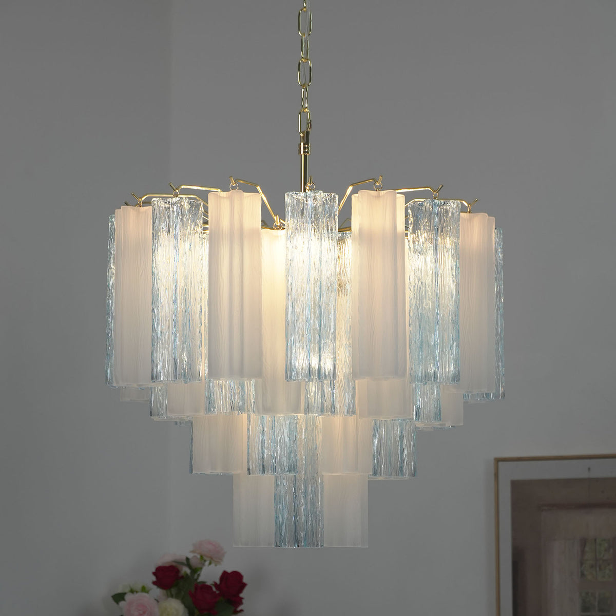 Givrane Two-Tone Glass Tube Tiered Chandelier | Two-Tone Glass and Brass | Real-life illuminated view glowing softly against a dark grey background | Severn Lighting