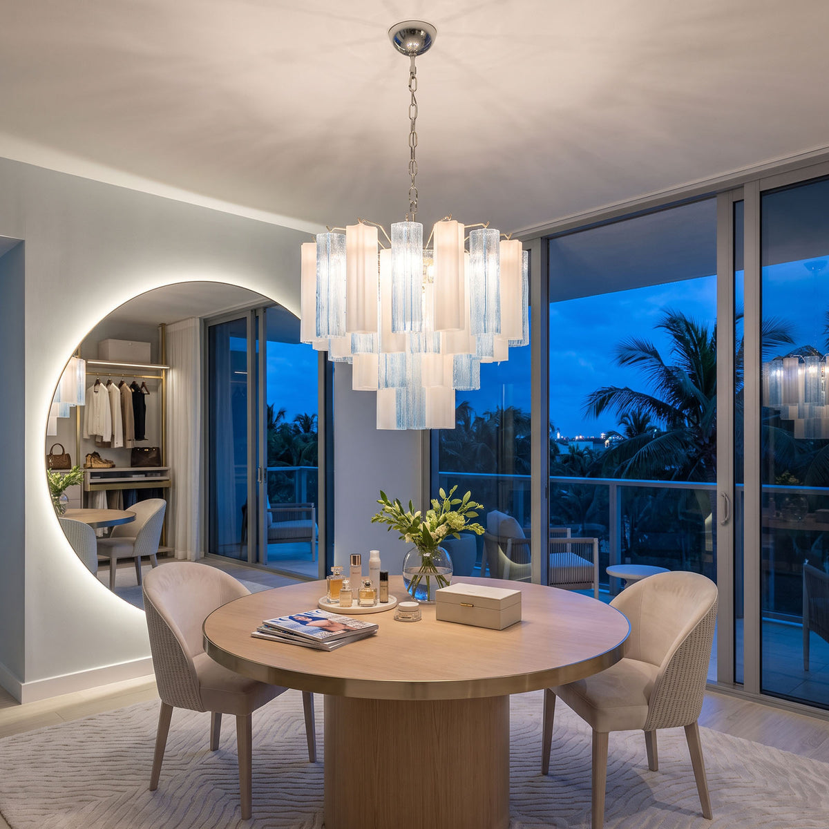 Givrane Two-Tone Glass Tube Tiered Chandelier | Two-Tone Glass and Brass | Centered above a round dining table near an illuminated circular mirror | Severn Lighting
