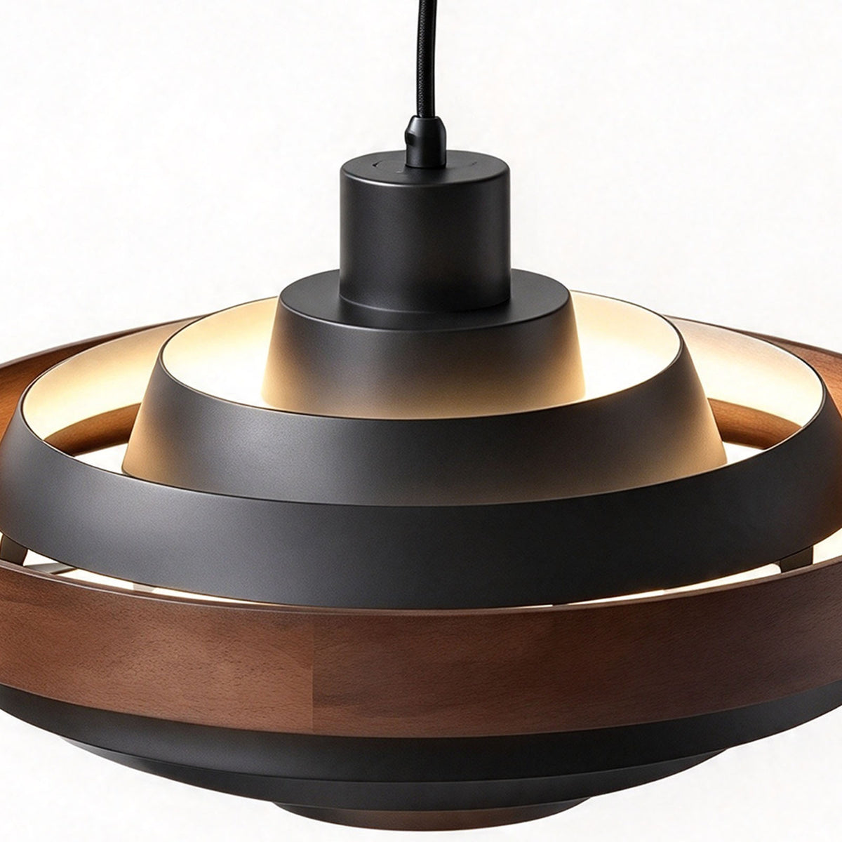 Holmvik Walnut Ring Tiered Metal Pendant Light | Walnut Wood and Metal | Top-down angled detail showing glowing black tiered metal rings and wood band | Severn Lighting