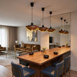 Holmvik Walnut Ring Tiered Metal Pendant Light | Walnut Wood and Metal | Hanging over a long wooden dining table reflected in a large wall mirror | Severn Lighting