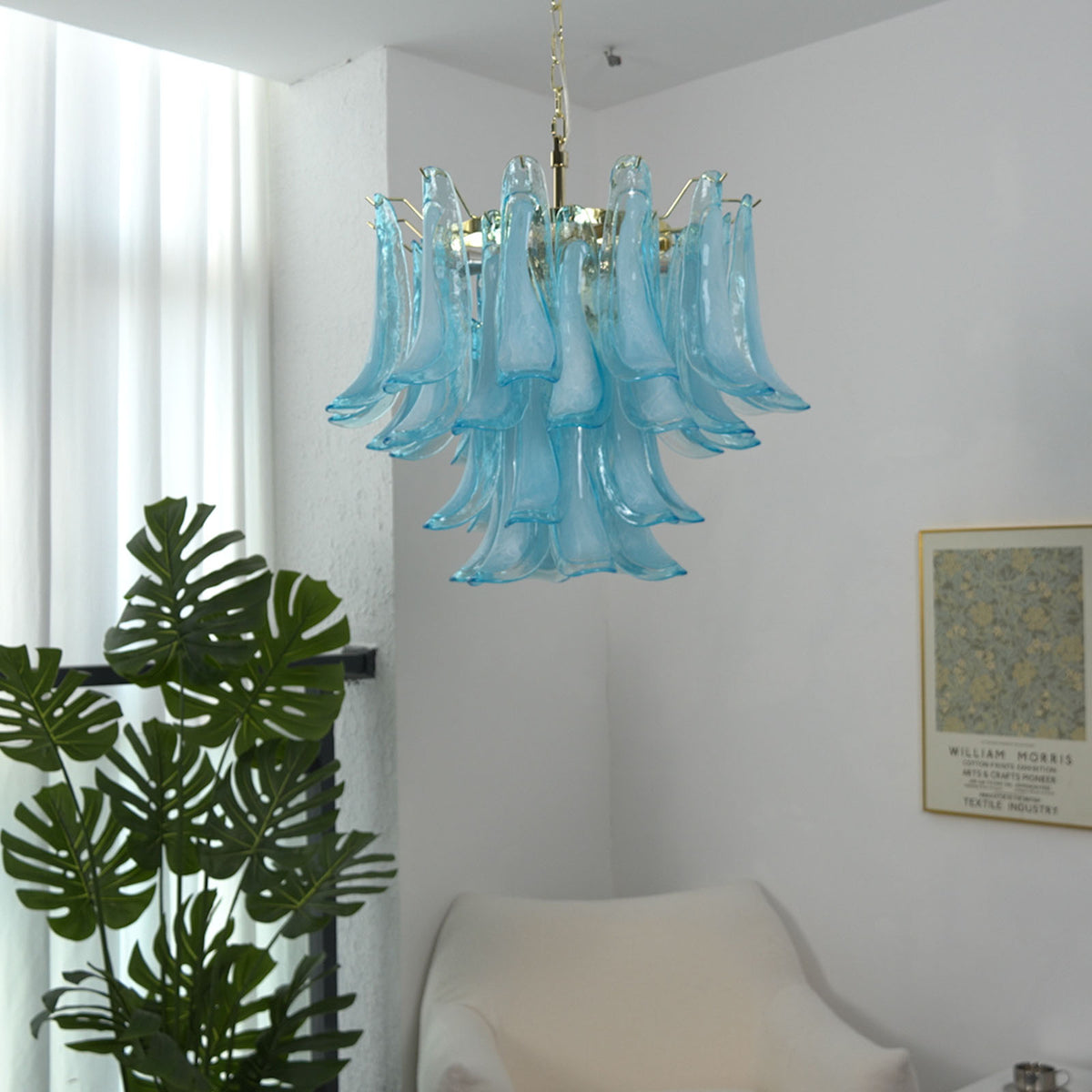 Isar Blue Petal Glass Chandelier | Blue Glass and Brass | Displayed in a room corner beside a tall green indoor houseplant | Severn Lighting