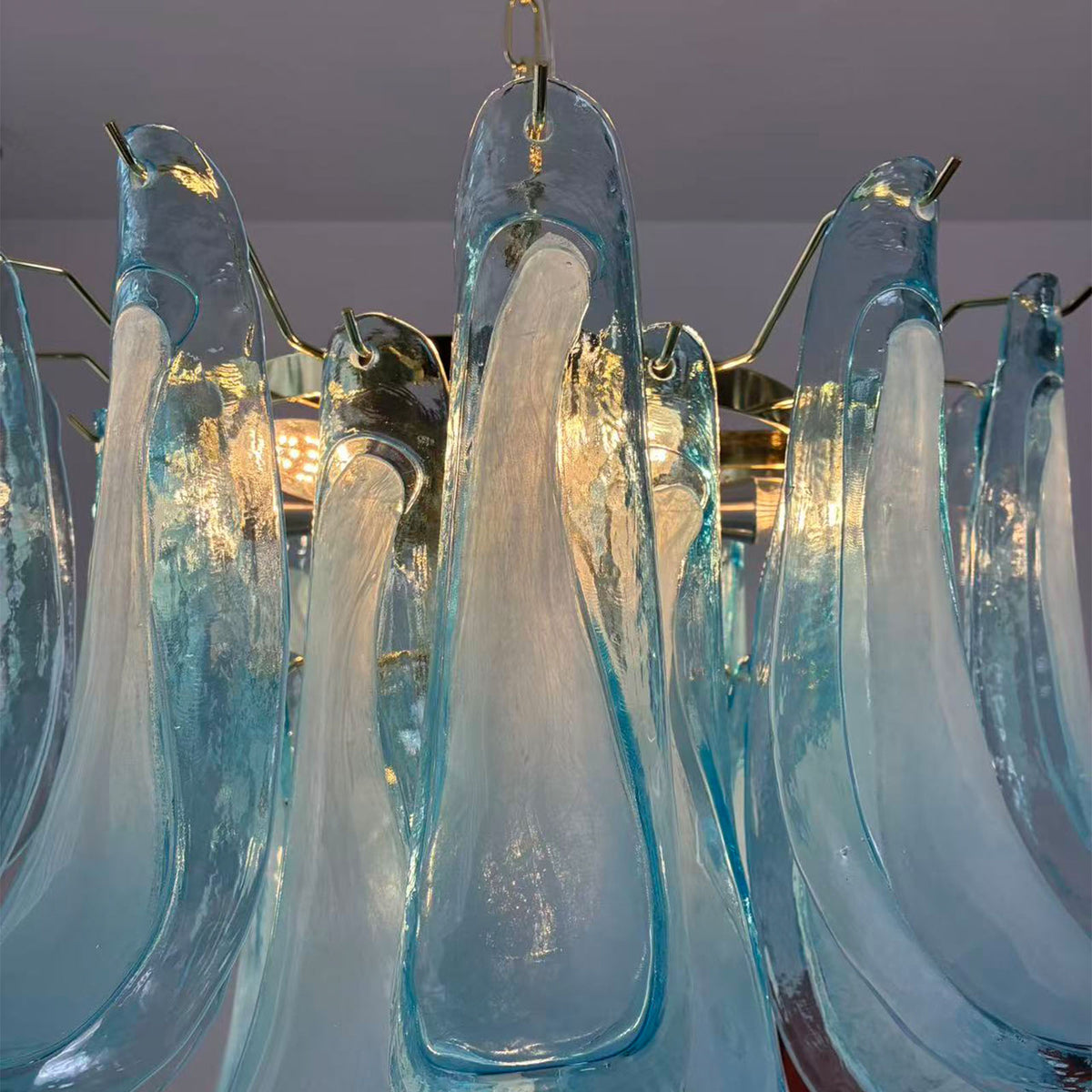 Isar Blue Petal Glass Chandelier | Blue Glass and Brass | Detail shot of blue glass petal tips attached to brass mounting hardware | Severn Lighting
