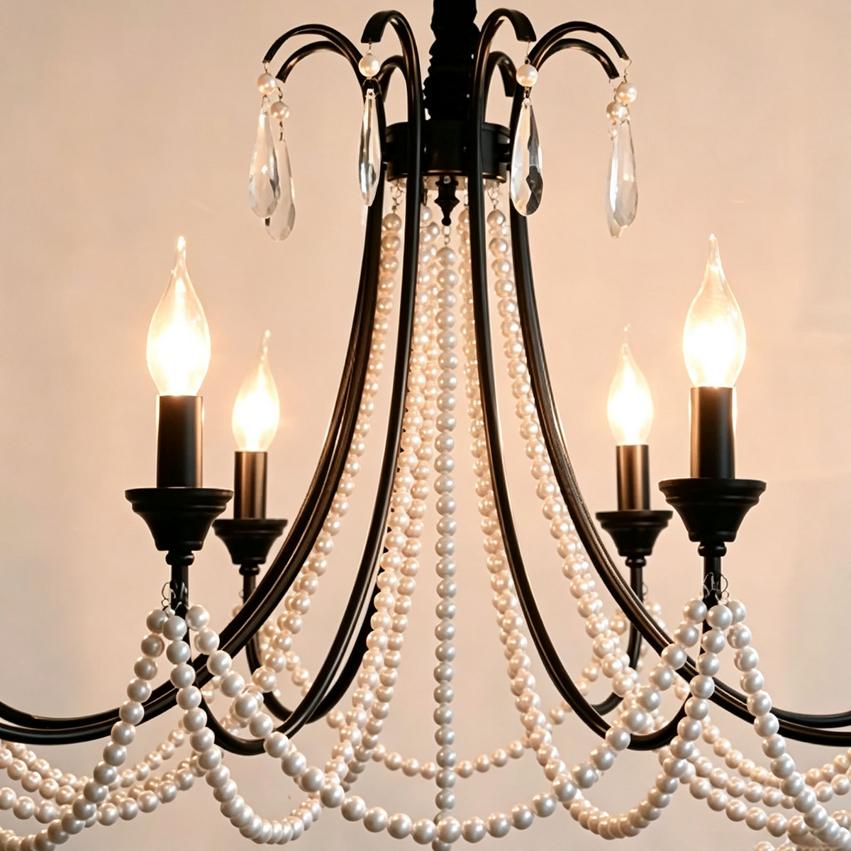 Isolde Pearl Swag Candle Chandelier | Pearl Beads, Crystal and Metal | Angled view showing top black scroll arms and glowing candle lights | Severn Lighting