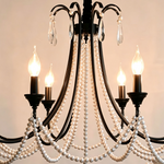 Isolde Pearl Swag Candle Chandelier | Pearl Beads, Crystal and Metal | Angled view showing top black scroll arms and glowing candle lights | Severn Lighting
