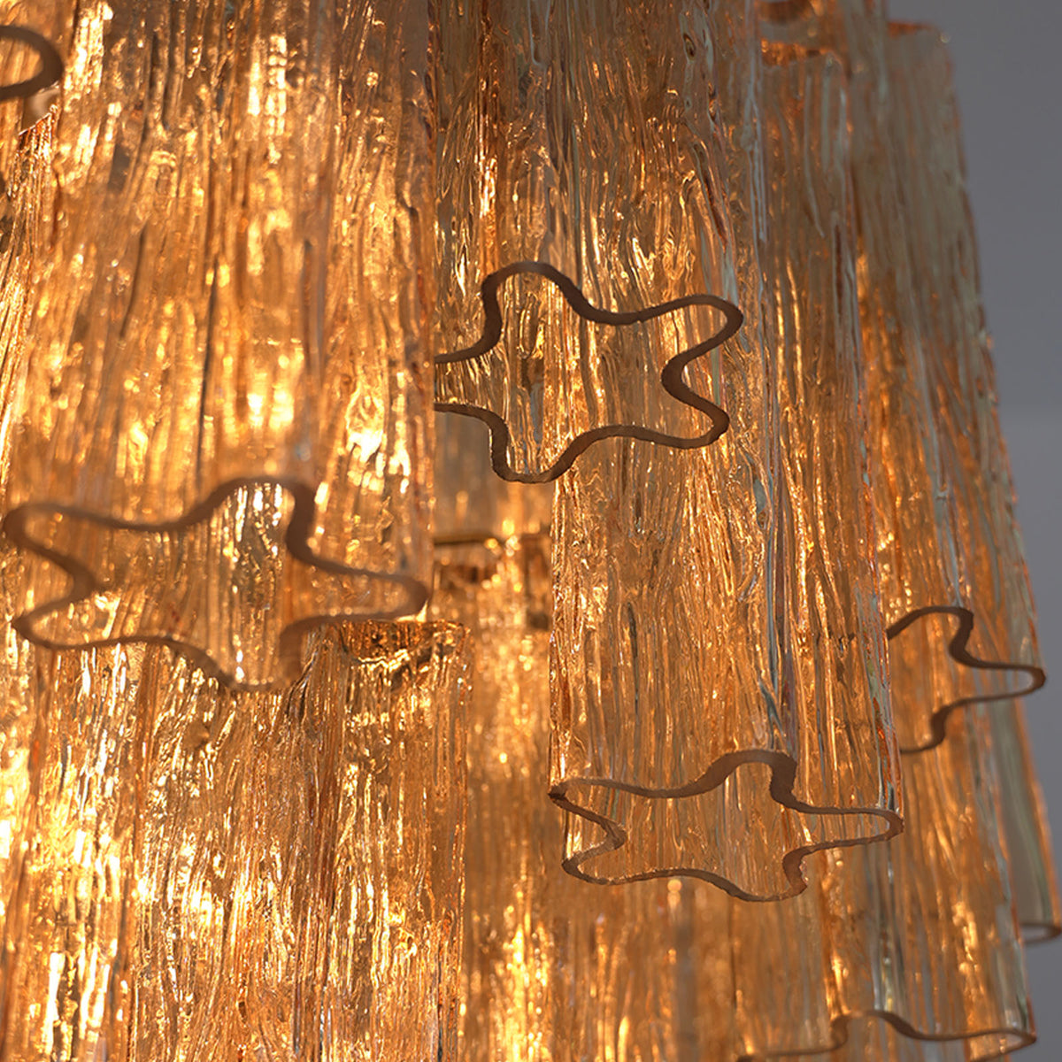 Kester Amber Glass Tier Chandelier | Amber Glass and Brass | Close-up view highlighting the glowing textured amber glass elements | Severn Lighting