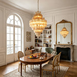 Kester Amber Glass Tier Chandelier | Amber Glass and Brass | Illuminating a dining room above a dark wooden oval table | Severn Lighting