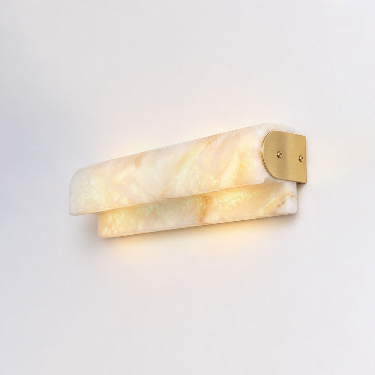Lamelune Stacked Sconce | Alabaster and Brass | Angled view on grey wall illuminated with warm ambient glow | Severn Lighting