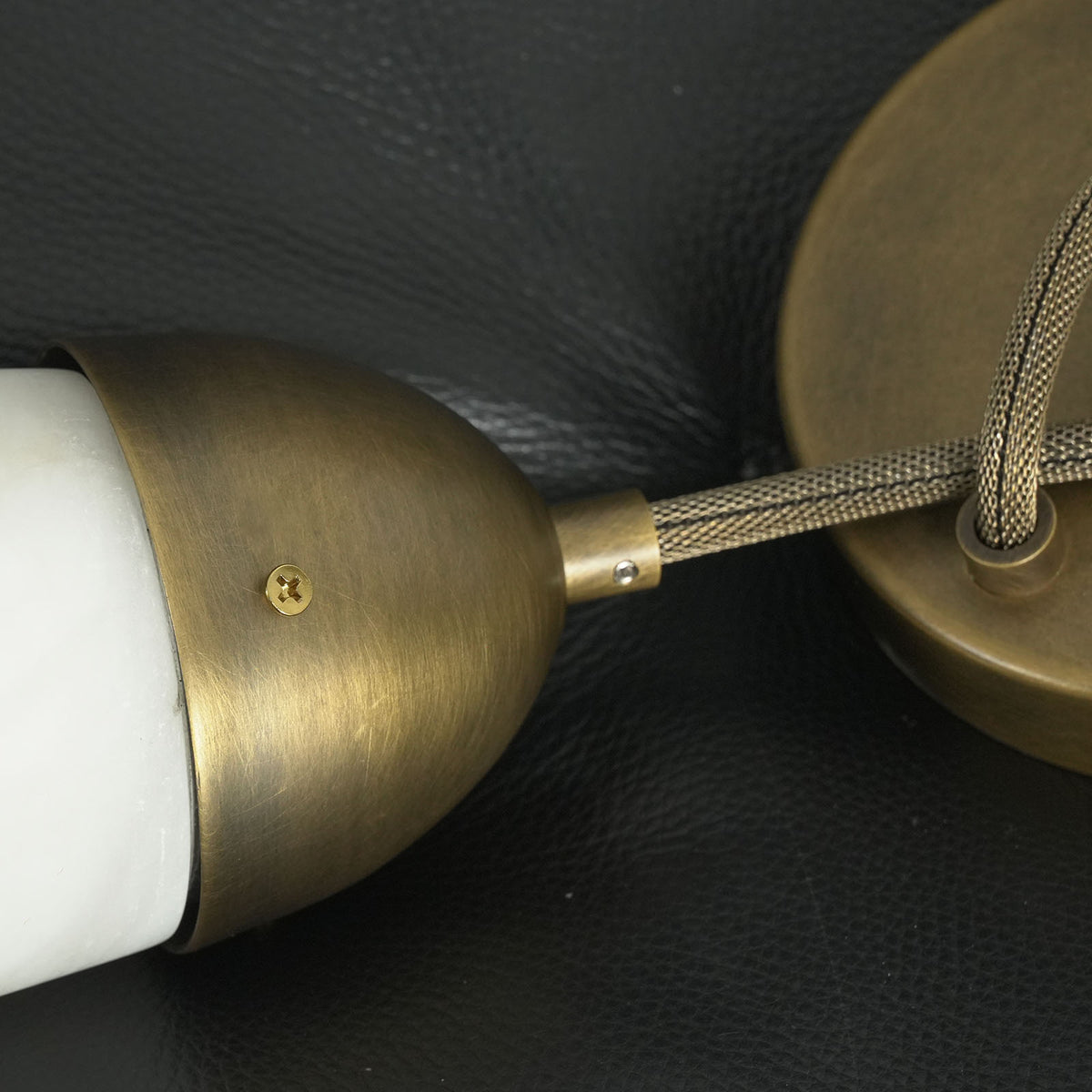 Larmelle Teardrop Sconce | Antique Brass and Cord | Close-up of brass dome cap and braided loop cord | Severn Lighting