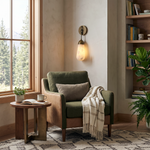 Larmelle Teardrop Sconce | Alabaster and Brass | Lit beside green armchair and window with forest view | Severn Lighting