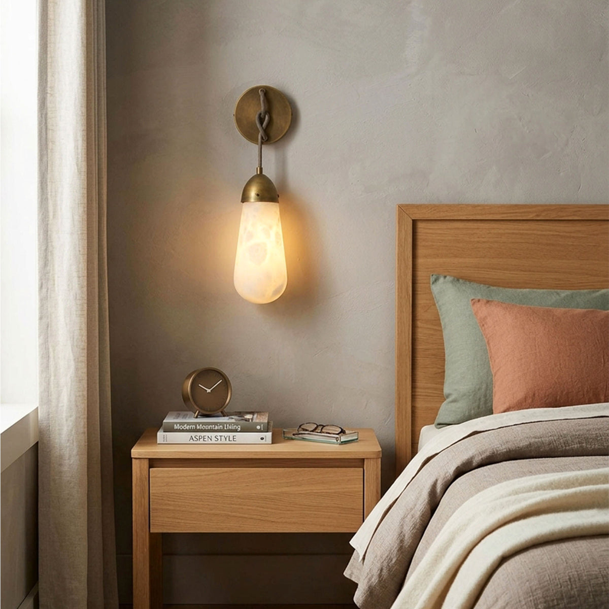Larmelle Teardrop Sconce | Alabaster and Brass | Mounted beside wooden headboard in neutral bedroom | Severn Lighting