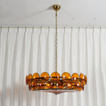 Lovenne Textured Glass Disc Ring Chandelier | Textured Glass and Brass | Studio product view of amber glass variant hanging on a pure white backdrop | Severn Lighting