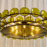 Lovenne Textured Glass Disc Ring Chandelier | Textured Glass and Brass | Front angled product view of the green glass chandelier illuminated warmly | Severn Lighting