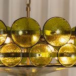 Lovenne Textured Glass Disc Ring Chandelier | Textured Glass and Brass | Close-up view of glowing green glass discs on the polished brass frame ring | Severn Lighting
