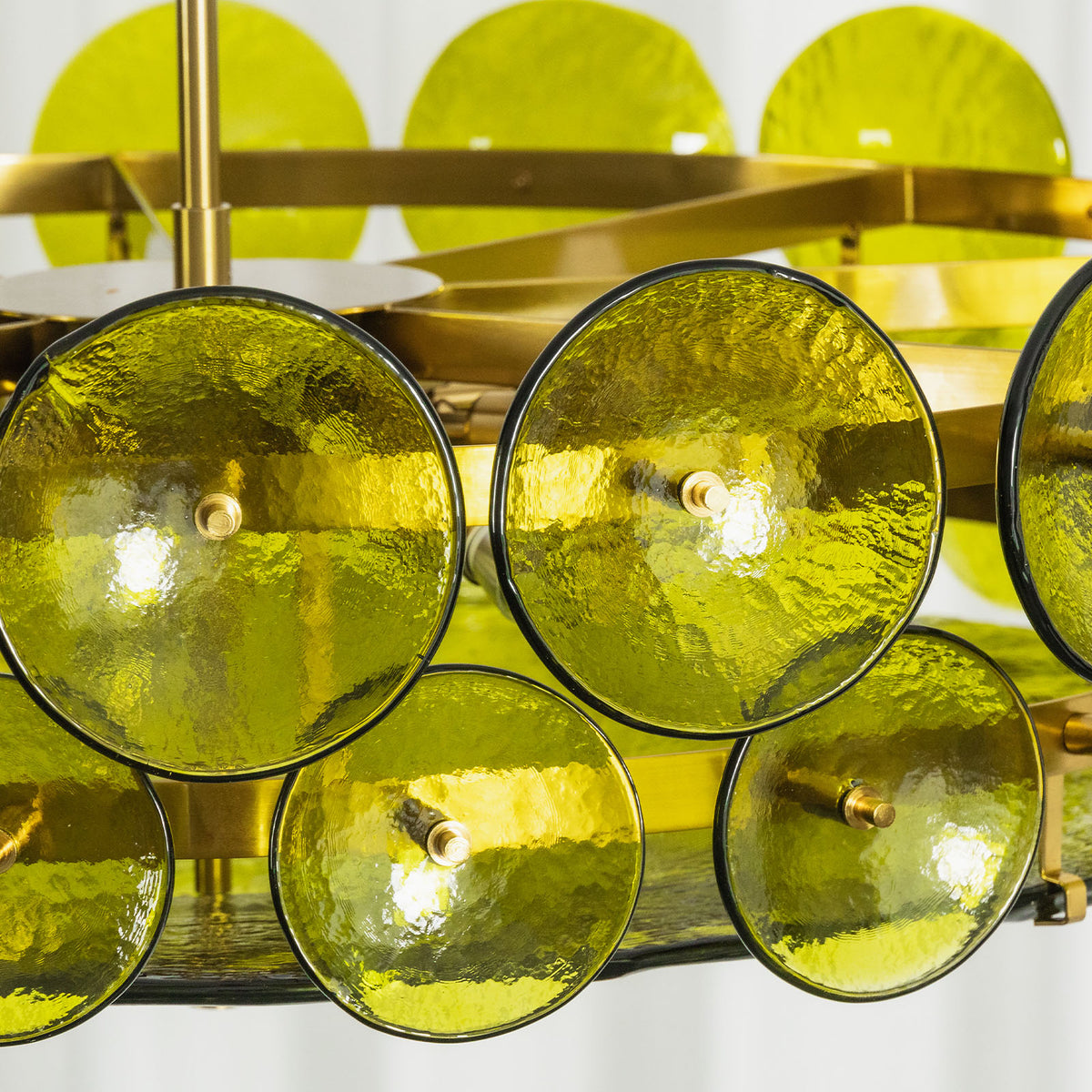 Lovenne Textured Glass Disc Ring Chandelier | Textured Glass and Brass | Macro close-up shot highlighting the dimpled texture of the green glass disc | Severn Lighting