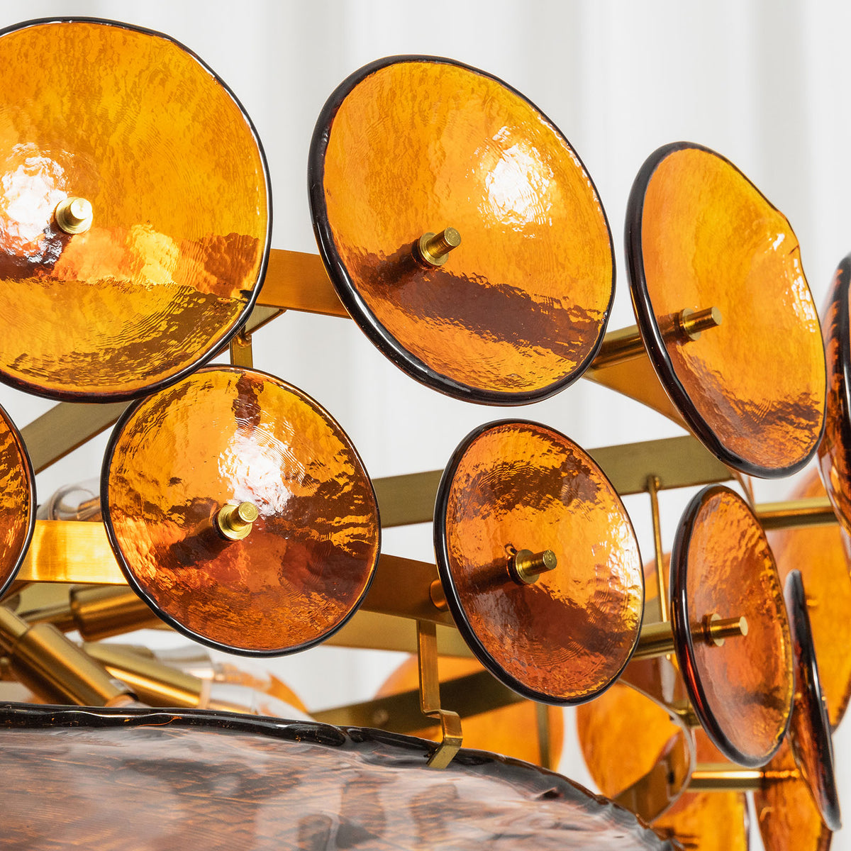 Lovenne Textured Glass Disc Ring Chandelier | Textured Glass and Brass | Close-up detail of amber textured glass discs mounted on the brass ring frame | Severn Lighting