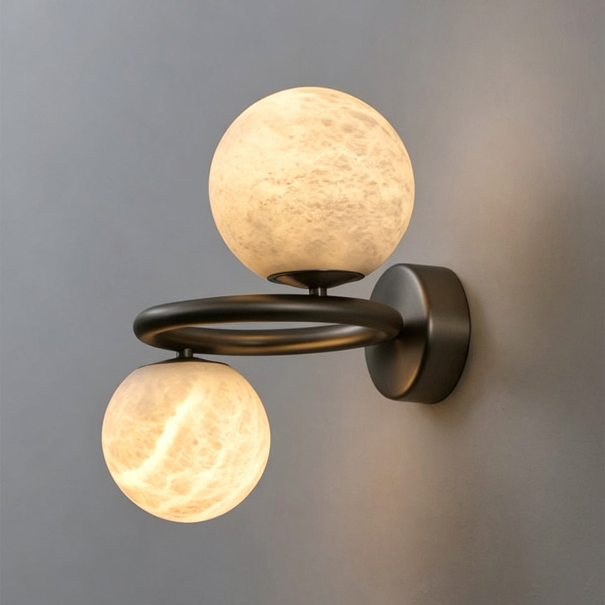 Lucern Twin Globe Alabaster Wall Sconce | Natural Alabaster and Matte Black Metal | Placed on a dark charcoal wall showcasing the warm contrast of the lit stone globes | Severn Lighting