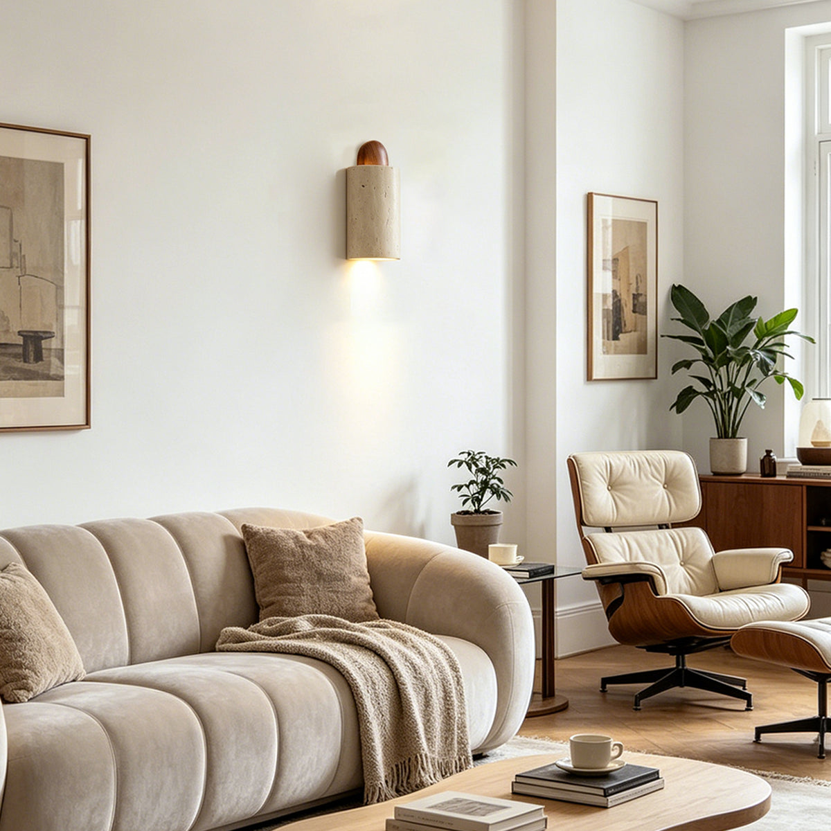 Lyra Travertine Shield Wall Lamp | Travertine, Wood, Metal | Illumination on a living room wall overlooking a contemporary cream fabric sofa and a classic lounge chair | Severn Lighting