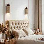 Lyra Travertine Shield Wall Lamp | Travertine, Wood, Metal | A pair of travertine stone wall sconces symmetrically mounted beside a luxury tufted beige headboard in a serene bedroom | Severn Lighting