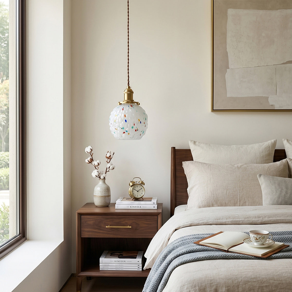 Marlowe Speckled Glass Pendant Lamp | Colorful Speckled Glass and Brass | Hanging as a bedside lamp above a dark wood nightstand in a bright elegant bedroom | Severn Lighting