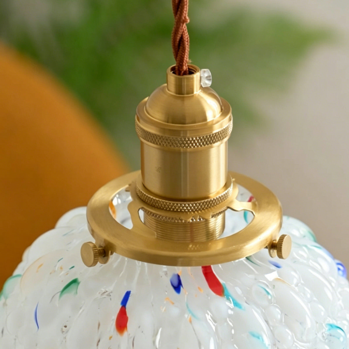 Marlowe Speckled Glass Pendant Lamp | Colorful Speckled Glass and Brass | Detailed close-up of the gold brass socket and cord connection atop the textured glass shade | Severn Lighting