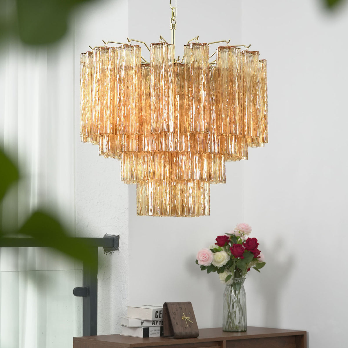 Merlande Amber Glass Tube Tiered Chandelier | Fluted Amber Glass and Brass | Real-life installation view displayed near a white wall and staircase corner | Severn Lighting