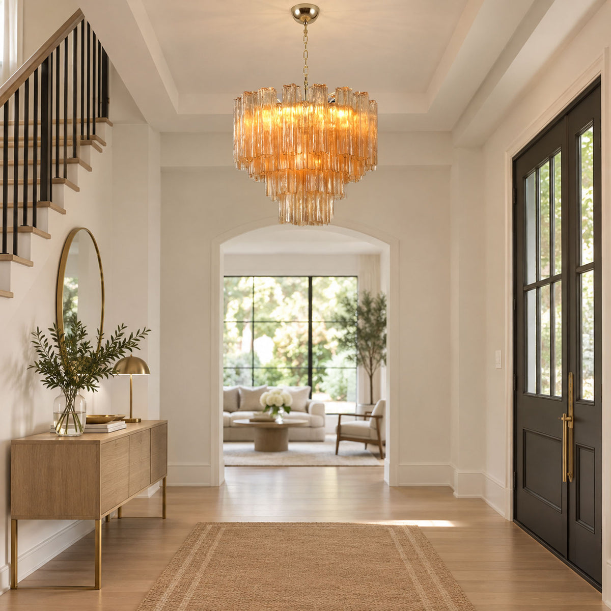 Merlande Amber Glass Tube Tiered Chandelier | Fluted Amber Glass and Brass | Hanging in a grand entry foyer corridor with a console table and staircase | Severn Lighting