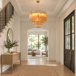 Merlande Amber Glass Tube Tiered Chandelier | Fluted Amber Glass and Brass | Hanging in a grand entry foyer corridor with a console table and staircase | Severn Lighting