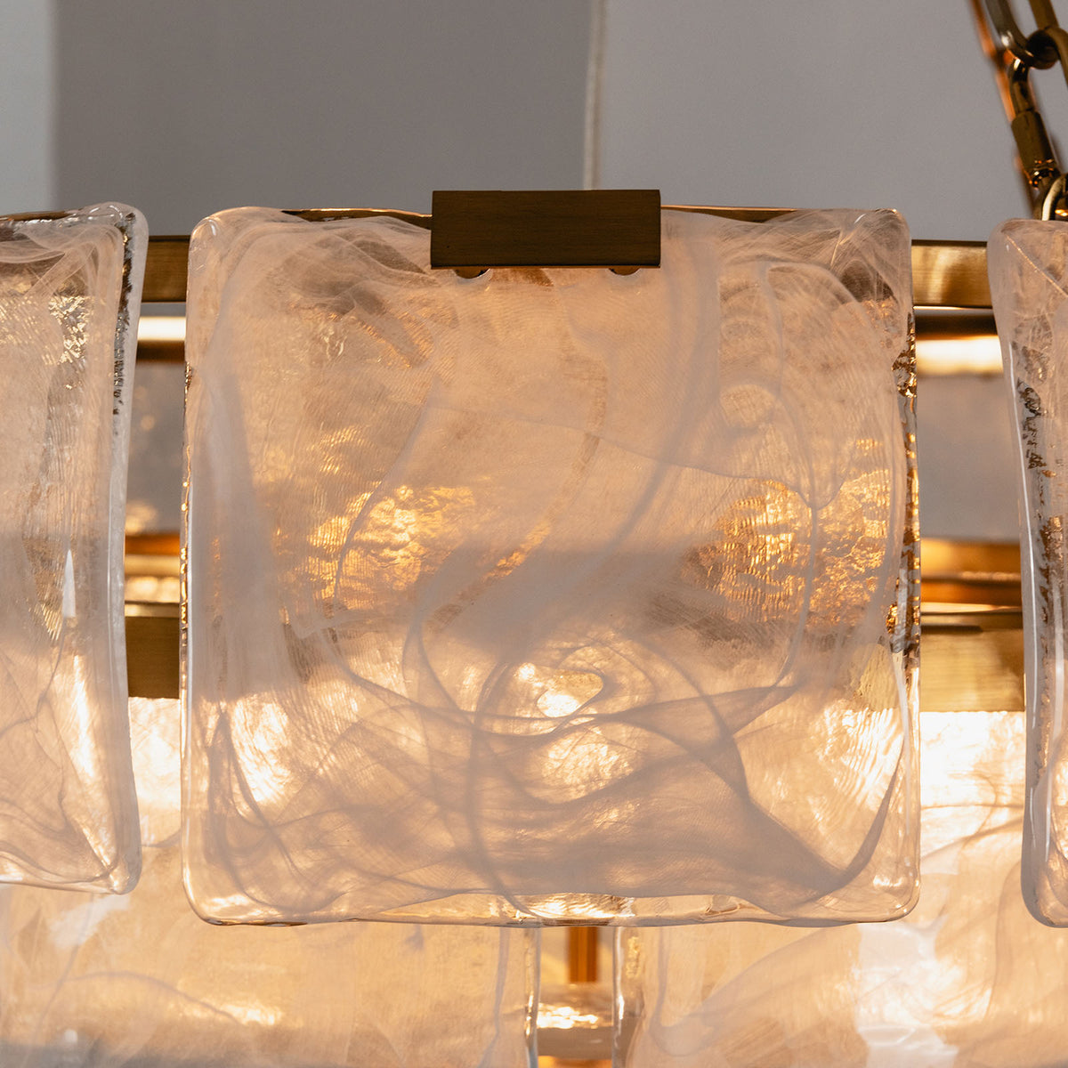 Nyle Tiered Glass Ring Chandelier | Textured Glass and Brass | Close-up view highlighting glowing textured glass plates and brass rim | Severn Lighting
