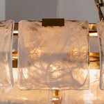 Nyle Tiered Glass Ring Chandelier | Textured Glass and Brass | Close-up view highlighting glowing textured glass plates and brass rim | Severn Lighting