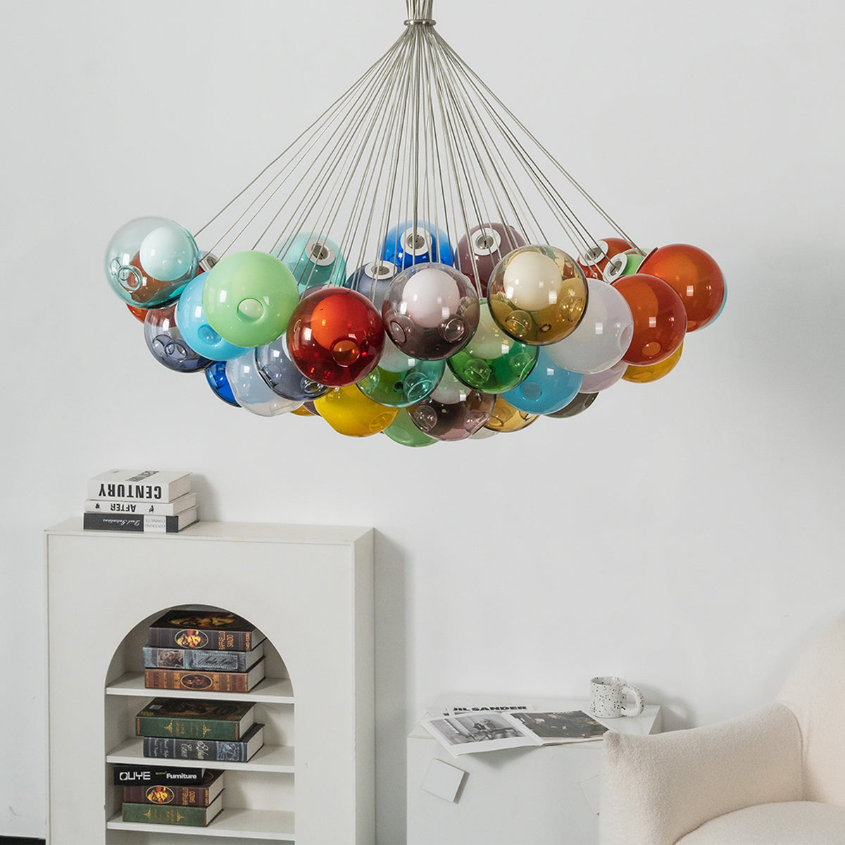 Rainbow Glass Bubble Cluster Chandelier | Multi-colored Blown Glass and Metal Cords | Suspended in a minimalist white interior space above a white storage cabinet with decorative items | Severn Lighting