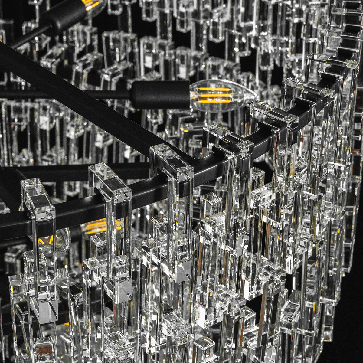 Rainer Cascading Glass Rod Chandelier | Clear Glass and Black Metal | Close-up shot showing black metal frame and internal light sockets | Severn Lighting