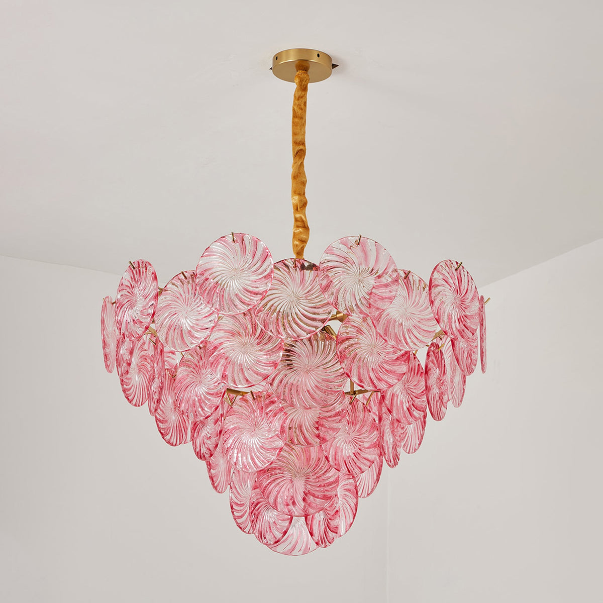 Rosalind Petal Glass Chandelier | Textured Spiral Pink Glass and Gold Metal | Full view of the pink chandelier fully illuminated against a light grey studio background | Severn Lighting