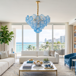 Rosalind Petal Glass Chandelier | Textured Spiral Blue Glass and Gold Metal | Casting a glow in a contemporary coastal living room with a cream sofa and ocean views | Severn Lighting