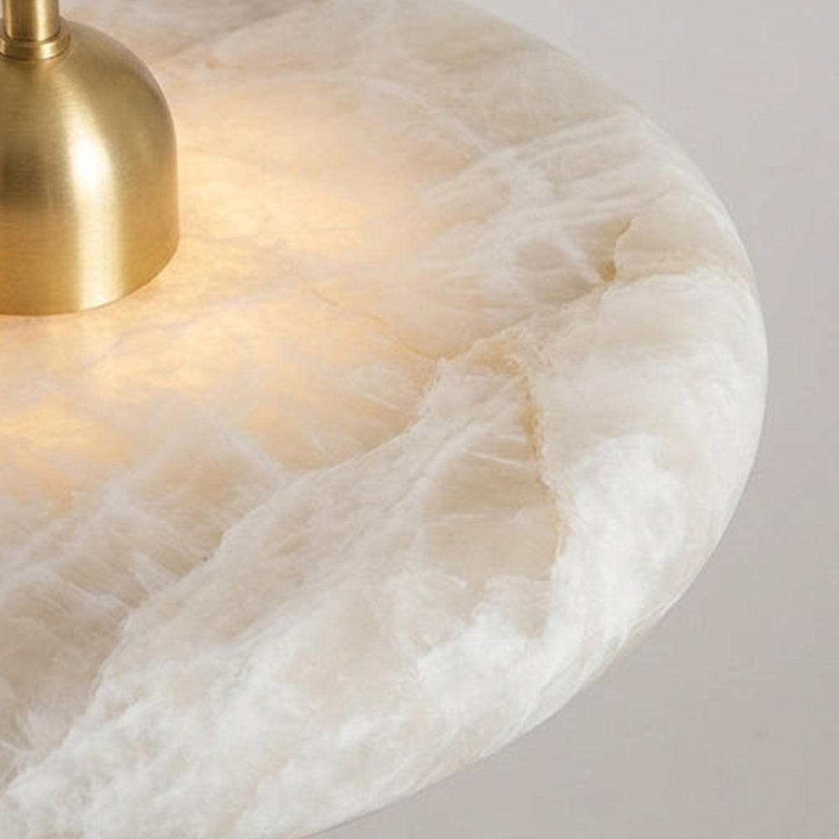 Sabine Alabaster Disc Pendant Light | Natural Alabaster and Brass | Macro detail showing the natural stone edge and top brass hardware | Severn Lighting